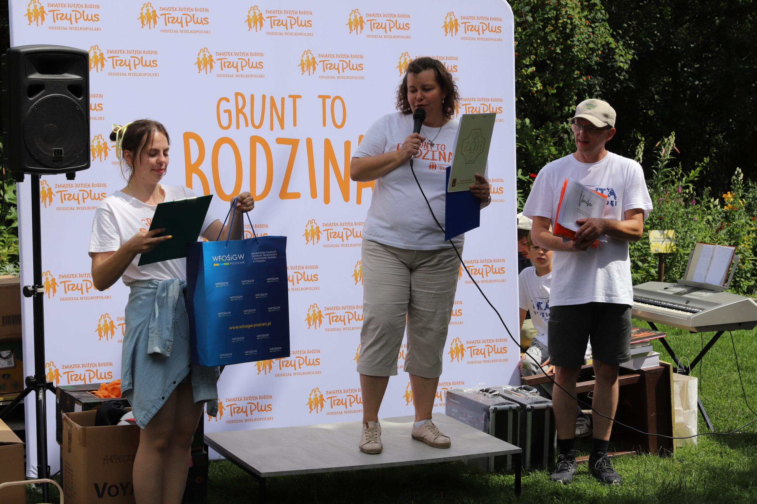 Na zdjęciu mała scena i na tle bannera reklamowego następuje wręczenie nagród.