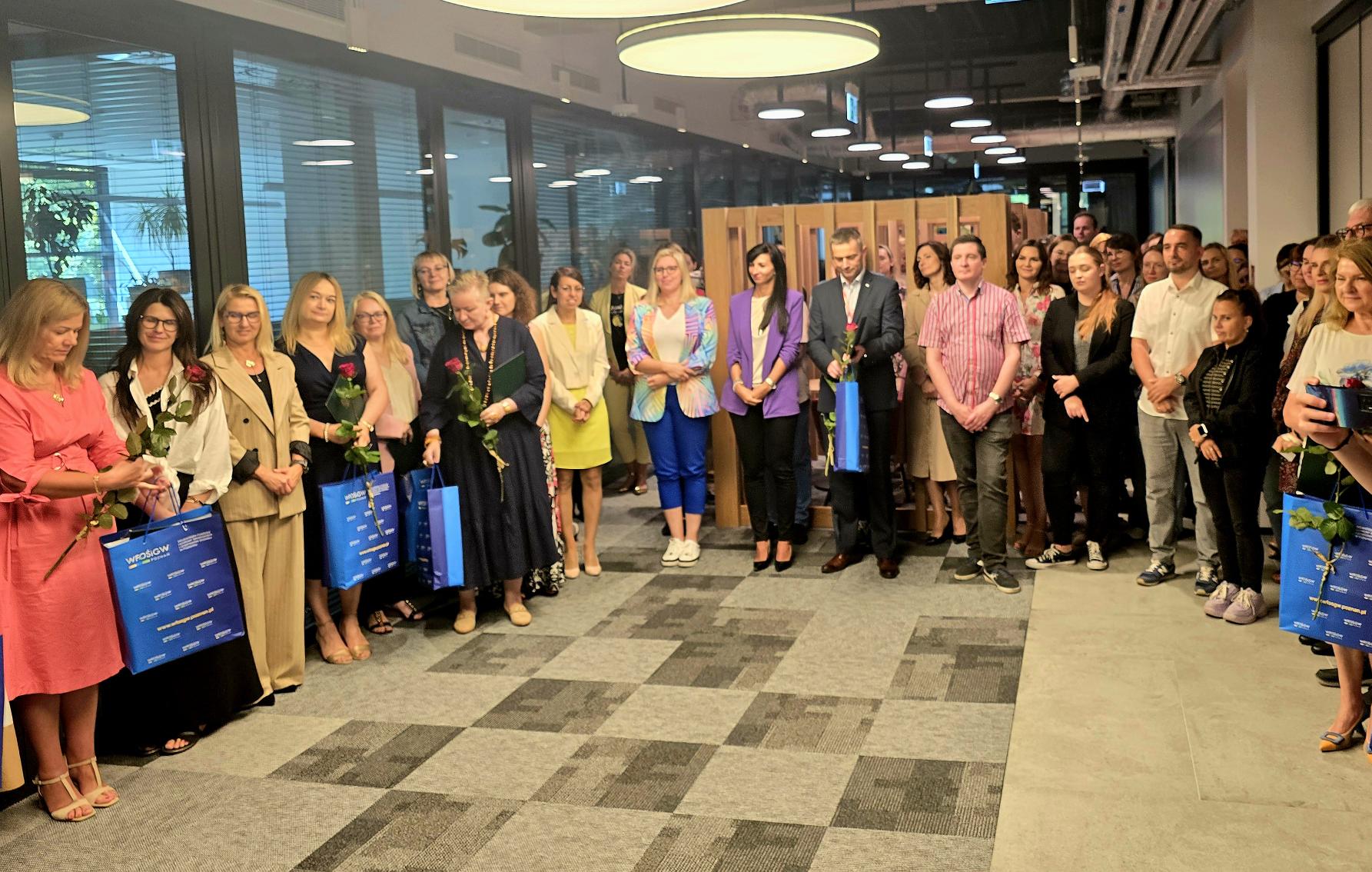 Zdjęcie przedstawia grupę ludzi stojących w holu.