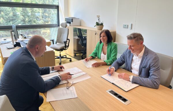 W biurze, w gabinecie Prezesa, przy stole siedzą 3 osoby, po prawej stronie Prezes Zarządu WFOŚiGW w Poznaniu wraz z Zastępcą Prezesa Zarząu oraz naprzeciwko, po lewej stronie zdjęcia Zastępca Prezesa Zarządu NFOŚiGW. Przed nimi na stole leżą dokument, a osoby rozmawiają.