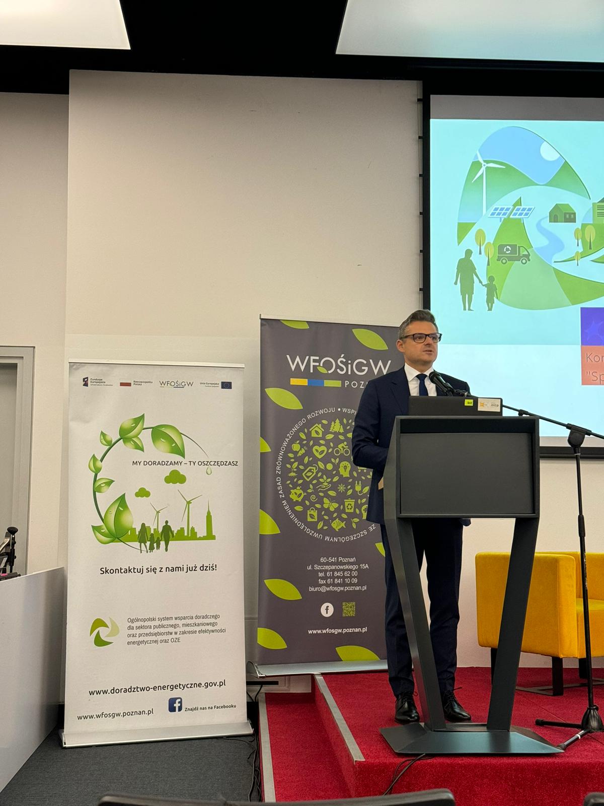 Prezes WFOŚiGW w Poznaniu stoi na scenie za mównicą i wygłasza przemówienie.