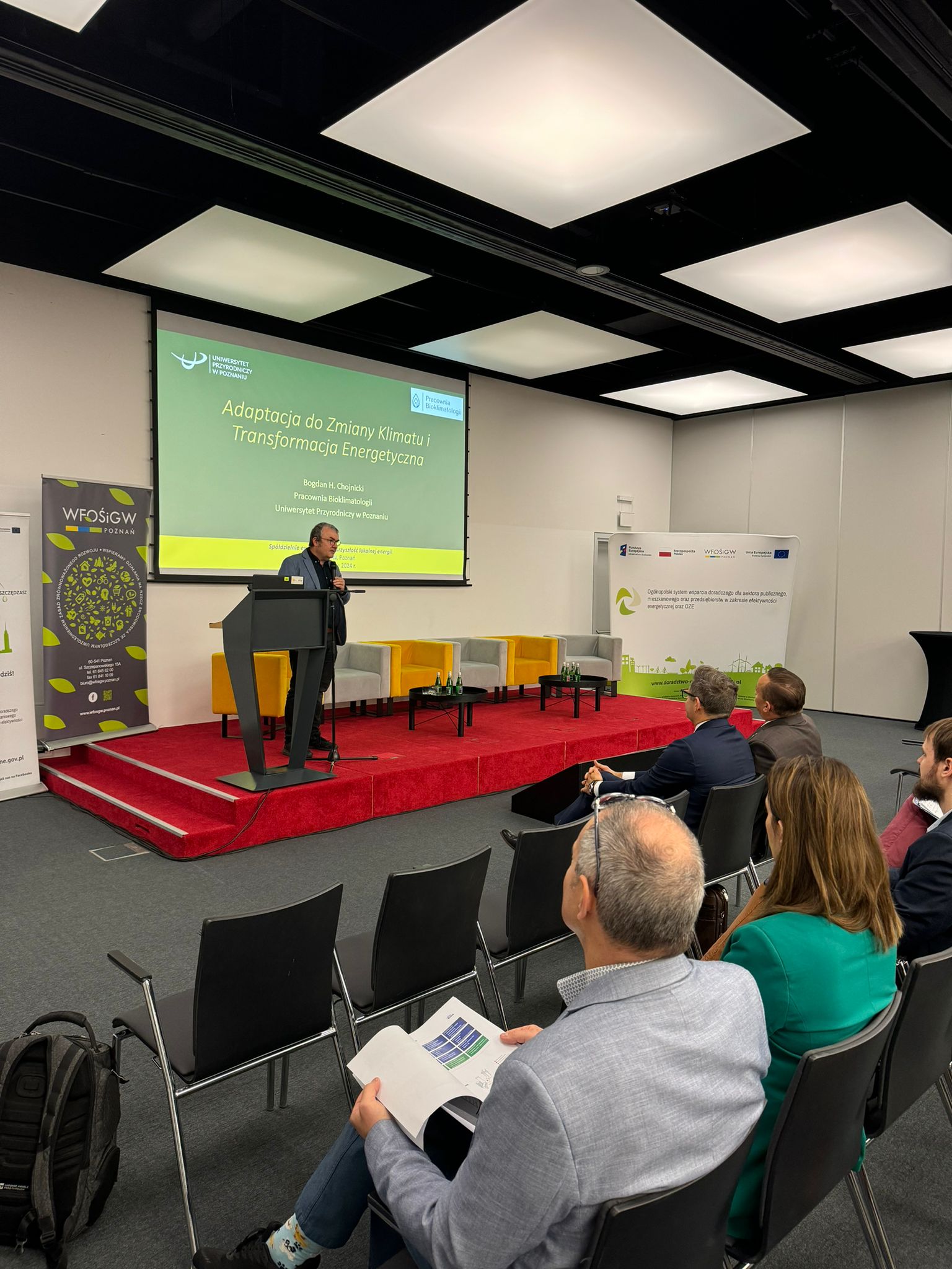 Prelegent stoi na scenie i wygłasza prelekcję.