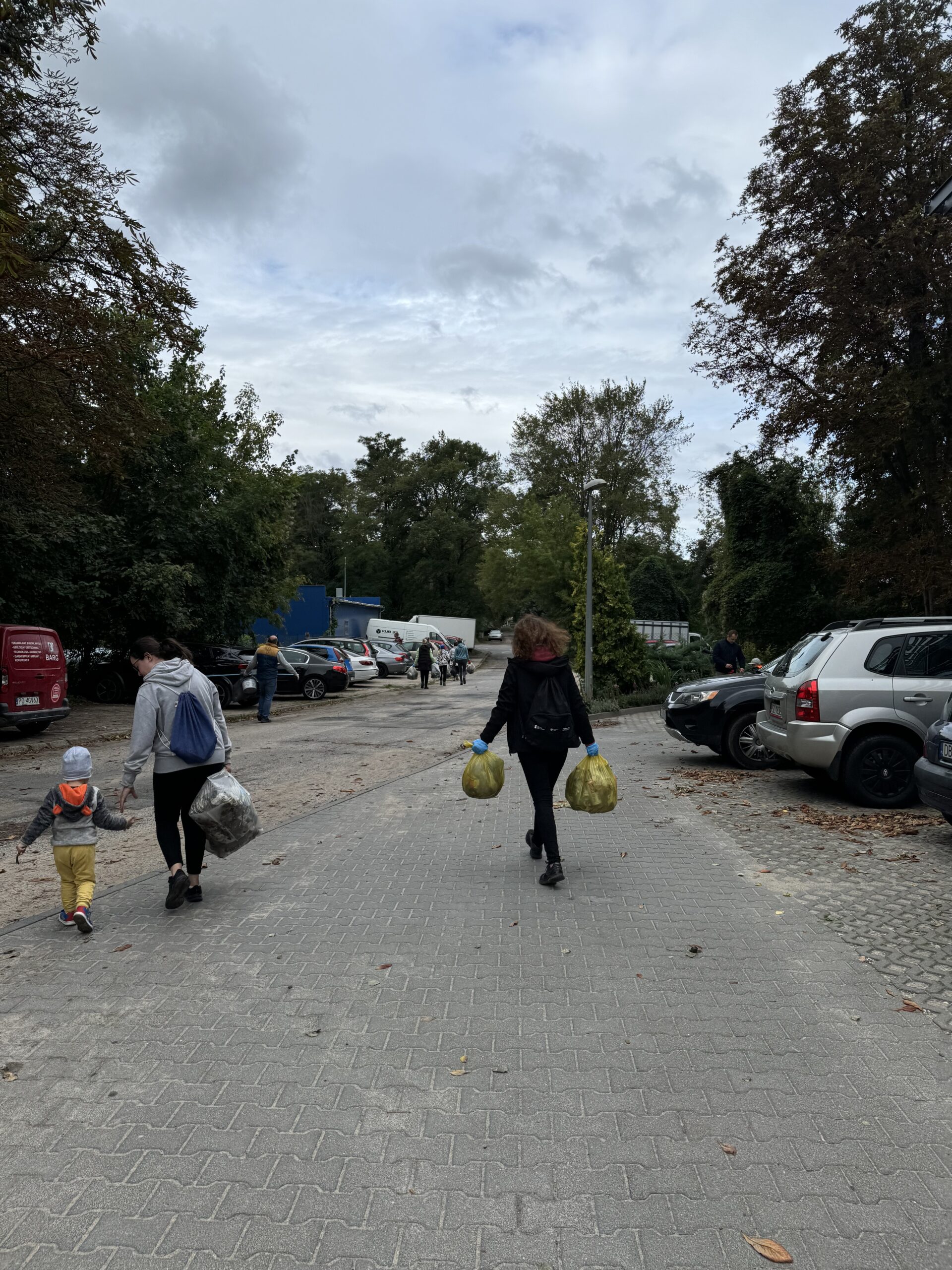 Pracownicy WFOŚiGW w Poznaniu podczas sprzątania okolicy w ramach akcji "Sprzątanie świata 2024" niosą worki nazbieranych odpadów.