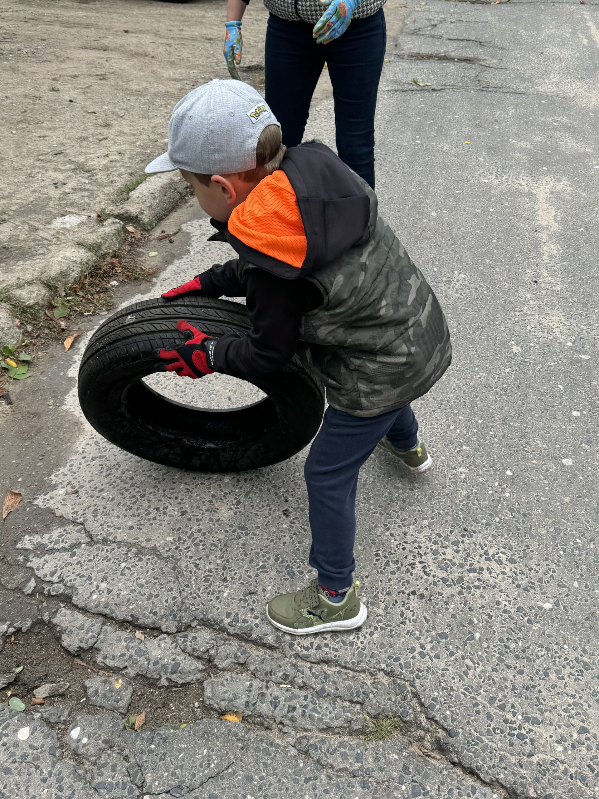 Nawet najmłodsi brali udział w akcji sprzątania wraz ze swoimi rodzicami. Na zdjęciu dziecko, które toczy oponę.
