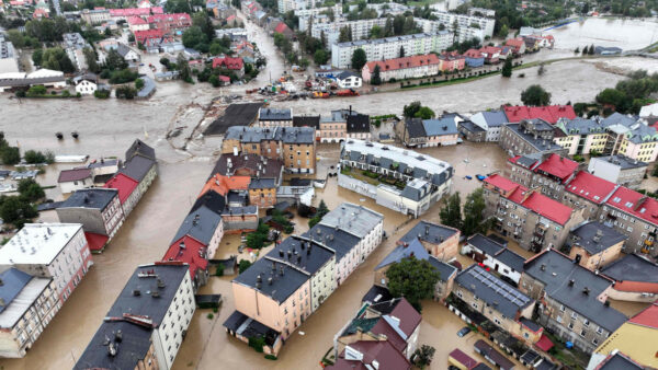 Zdjęcie przedstawia zalane miasto Głuchołazy, widać na nim stojącą wodę, zalane ulice, chodniki budynki i samochody.