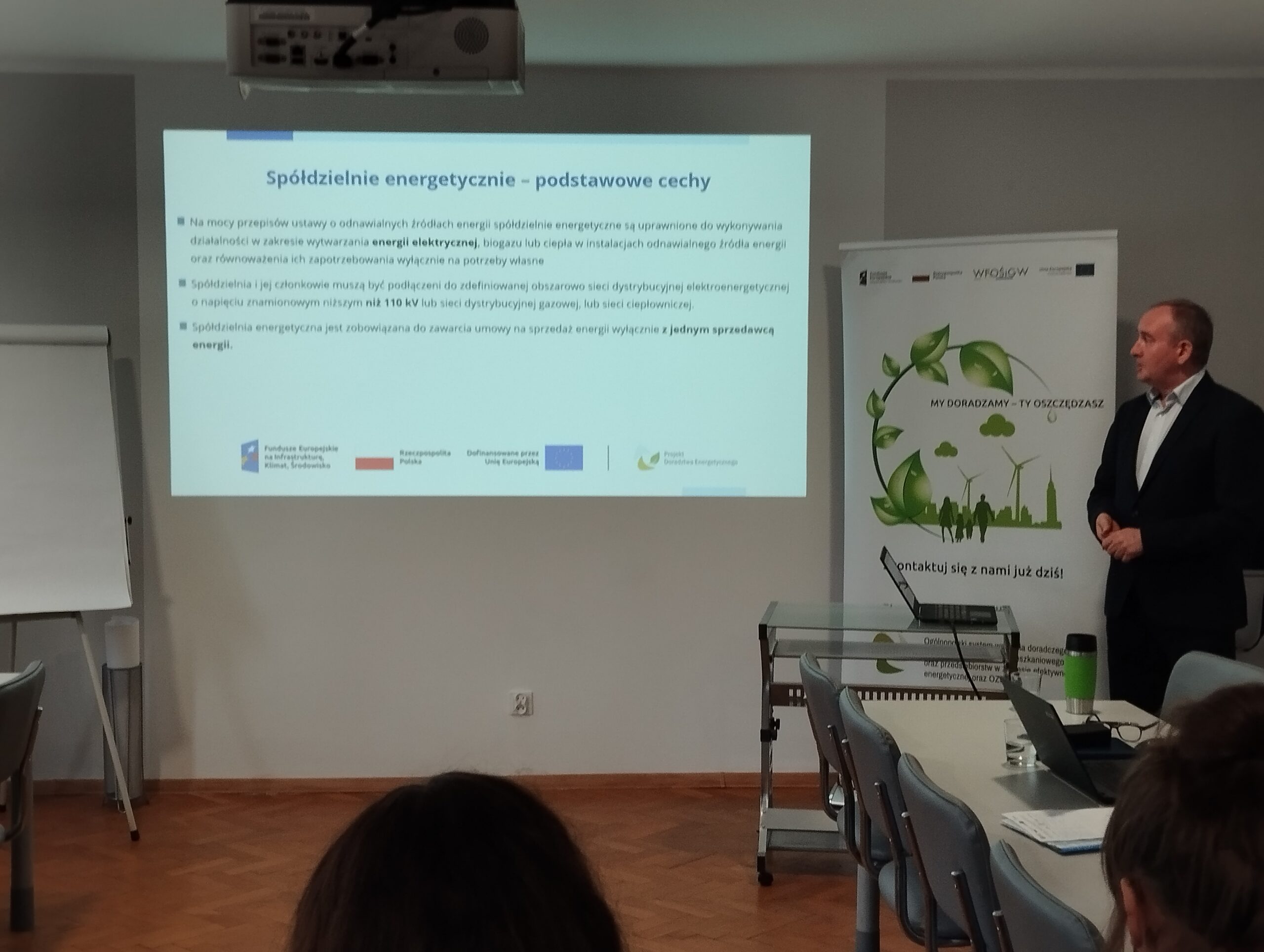 Widok na ekran projektora, na którym wyświetlana jest prezentacja podczas spotkania.