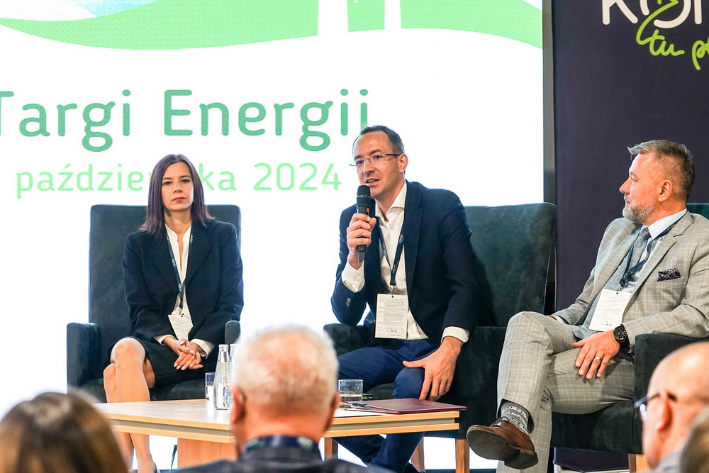 Na zdjęciu widać 3 panelistów w trakcie dyskusji, którzy siedzą na krzesłach i wypowiadają się do mikrofonu.