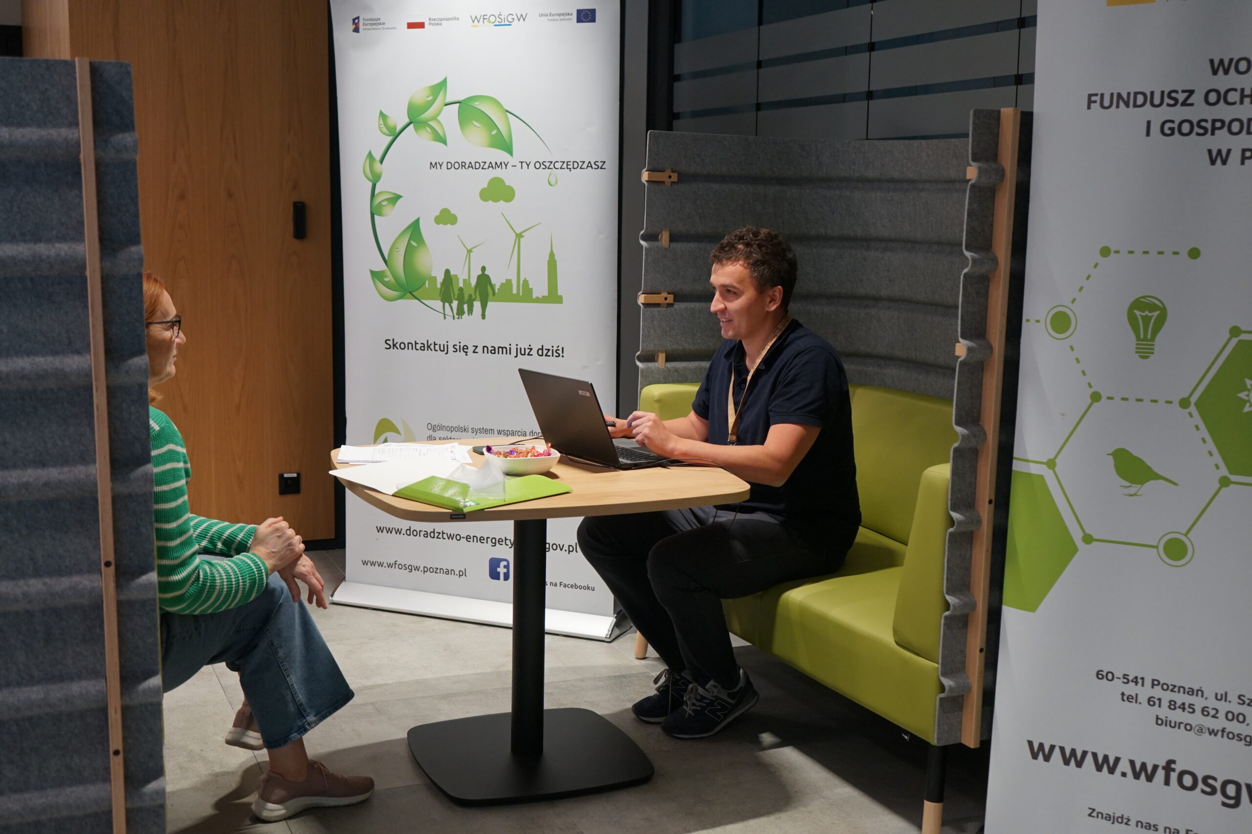 2 osoby siedzą przy stole i rozmawiają.