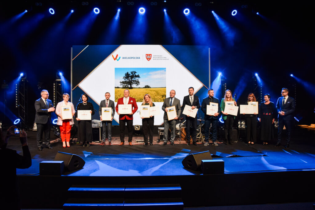 Na scenie podczas gali pozuje do zdjęcia 13 osób - finaliści konkursu oraz osoby wręczające nagrody.