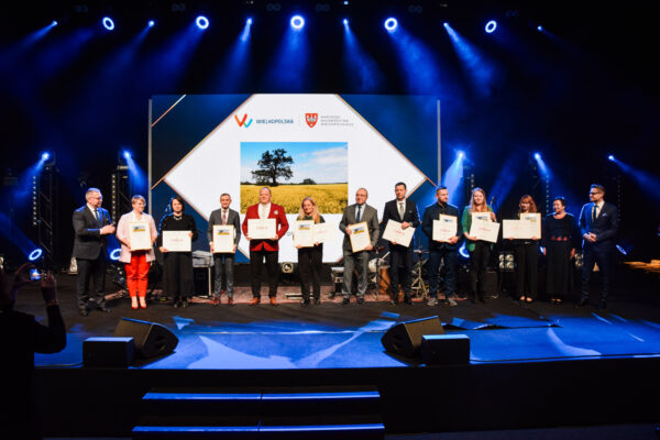 Na scenie podczas gali pozuje do zdjęcia 13 osób - finaliści konkursu oraz osoby wręczające nagrody.