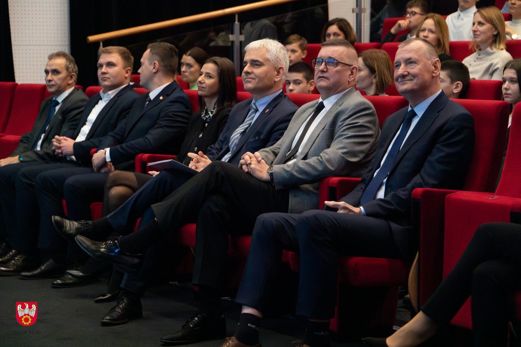 Zdjęcie przedstawia widok na salę z siedzącymi gośćmi.