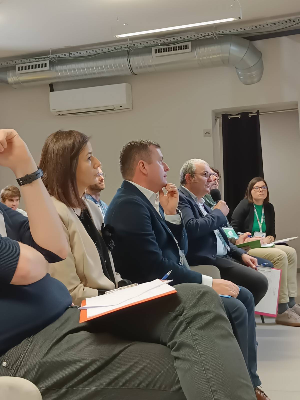 Zdjęcie przedstawia jury siedzących w pierwszym rzędzie na krzesłach.