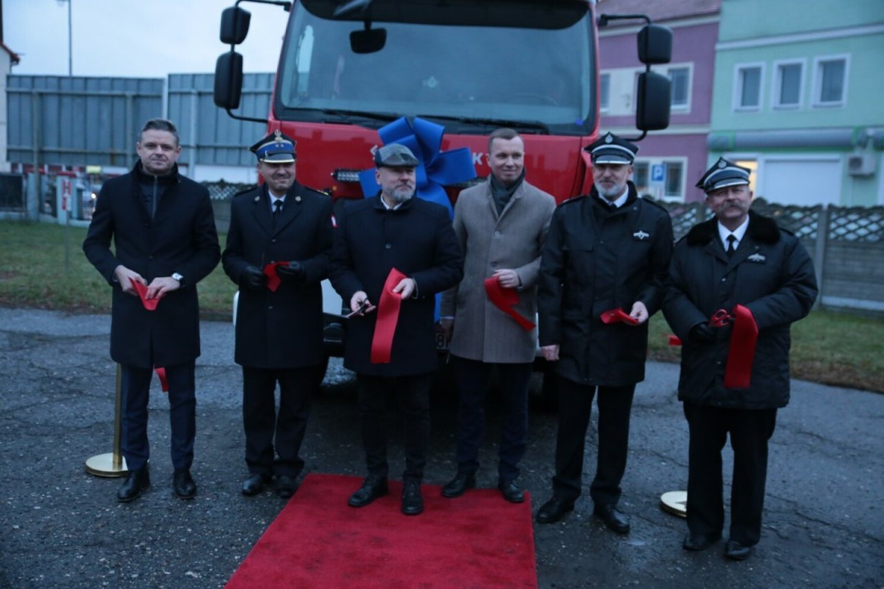 Na zdjęciu na tle nowego samochodu ratowniczo-gaśniczego stoją osoby, które przekazywały do niego kluczyki druhom z OSP Konin-Starówka.