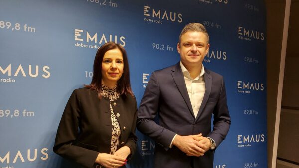 Dwie osoby stojące na tle ścianki w studiu radiowym