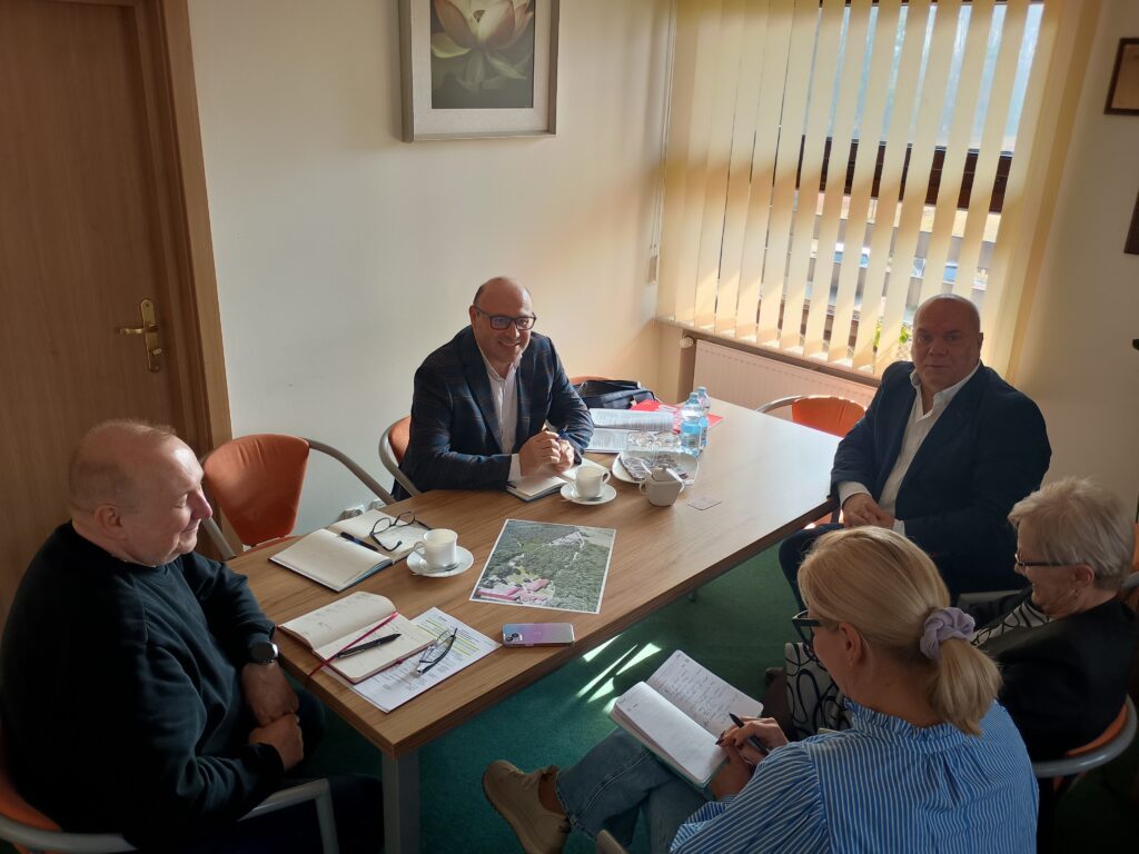 Przy stole siedzą łącznie 4 osoby i rozmawiają