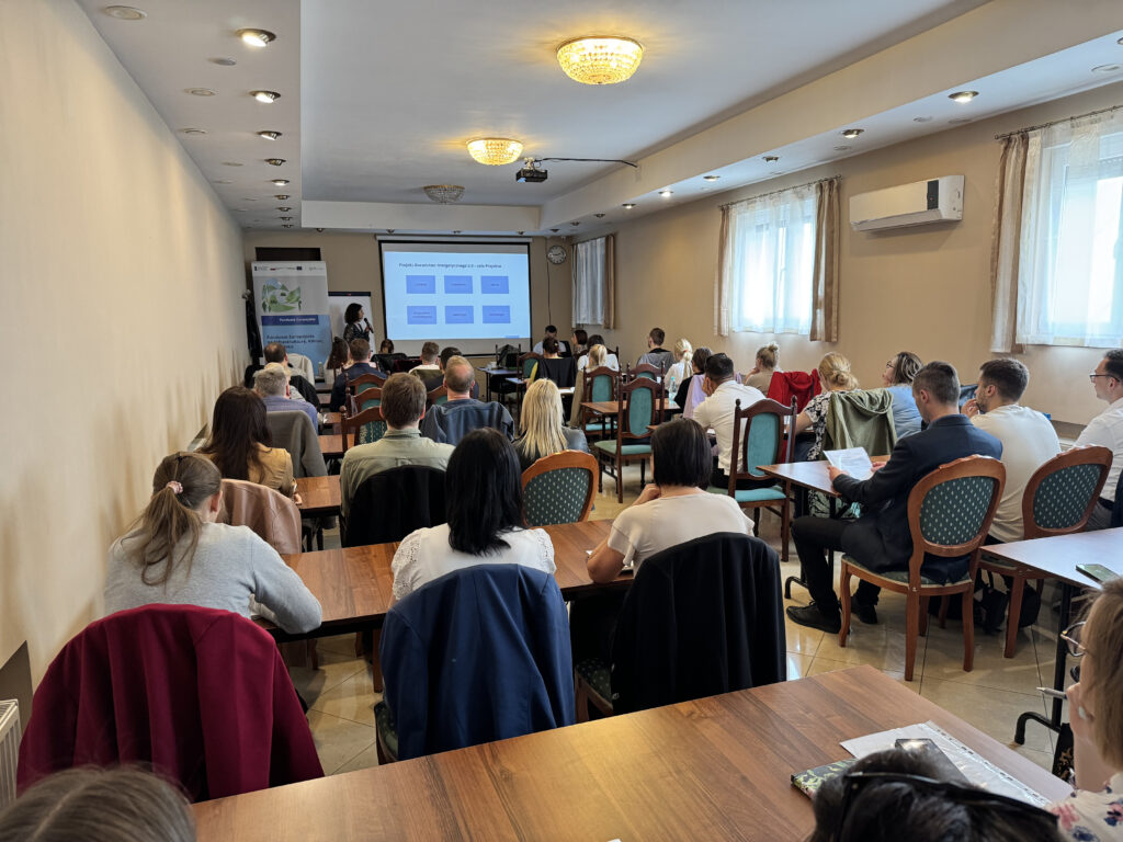 Widok na salę, na której uczestnicy szkolenia siedzą w ławkach.