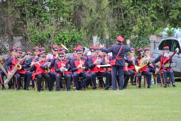 Na zdjęciu widzimy orkiestrę strażacką, która gra na instrumentach podczas wydarzenia.