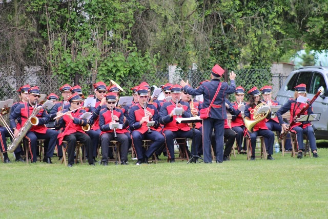 Na zdjęciu widzimy orkiestrę strażacką, która gra na instrumentach podczas wydarzenia.