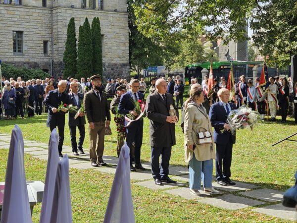 Na zdjęciu zgromadzeni ludzie podczas złożenia kwiatów pod Pomnikiem Ofiar Katynia i Sybiru.