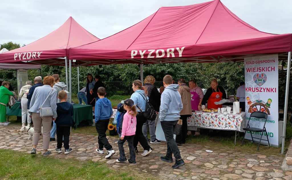 Zdjęcie przedstawia stoiskarozlokowane na terenie festynu Festiwal Jabłka i Śliwki w Pyzdrach.